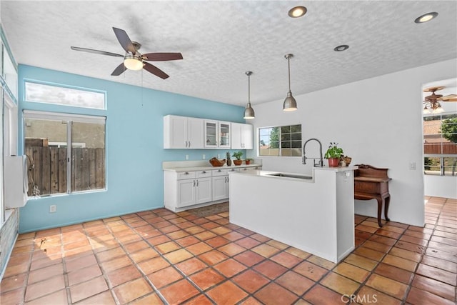 23633 Breezy Meadow Ct, Moreno Valley, CA 92557 - kitchen with a sink, a ceiling fan, white cabinets, healthy amount of natural light, and a textured ceiling