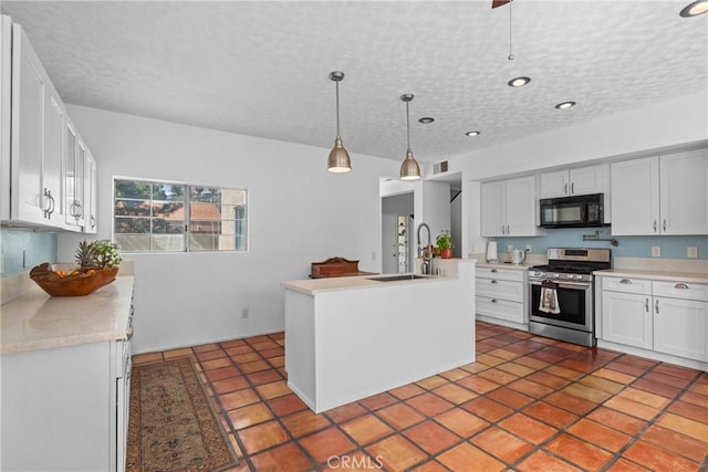 23633 Breezy Meadow Ct, Moreno Valley, CA 92557 - kitchen with stainless steel gas range, black microwave, a sink, light countertops, and a textured ceiling