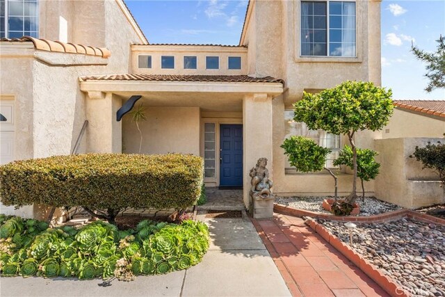 23633 Breezy Meadow Ct, Moreno Valley, CA 92557 - doorway to property with a tiled roof and stucco siding