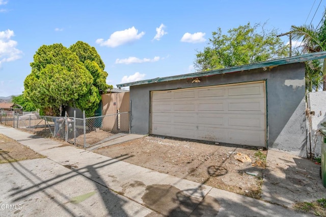 8731 Lucia Pl, Sun Valley, CA 91352 - view of front facade featuring stucco siding, fence, an outbuilding, and a detached garage