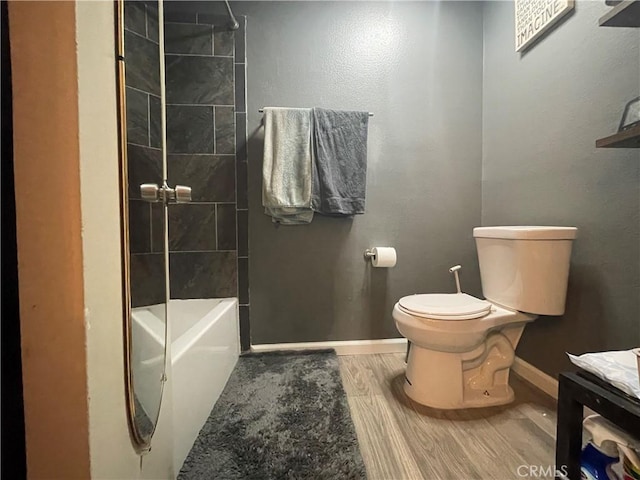 7800 Topanga Canyon Blvd Unit 208, Canoga Park, CA 91304 - bathroom featuring toilet, wood finished floors, baseboards, and bathing tub / shower combination
