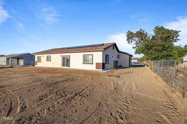 40719 E 171st St E, Lake Los Angeles, CA 93535 - rear view of property with roof mounted solar panels, fence, stucco siding, and a tile roof