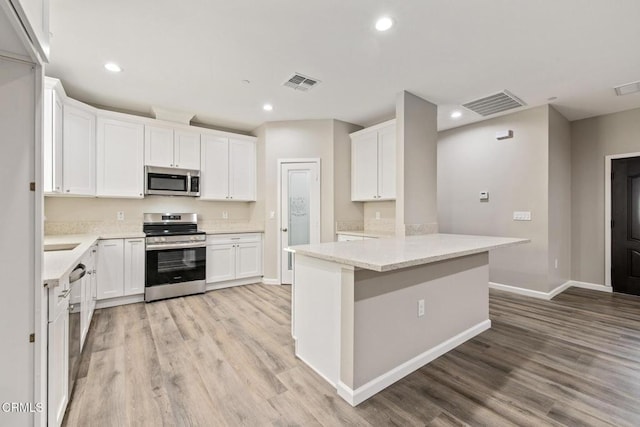 40719 E 171st St E, Lake Los Angeles, CA 93535 - kitchen featuring appliances with stainless steel finishes, light wood-style flooring, white cabinetry, baseboards, and recessed lighting