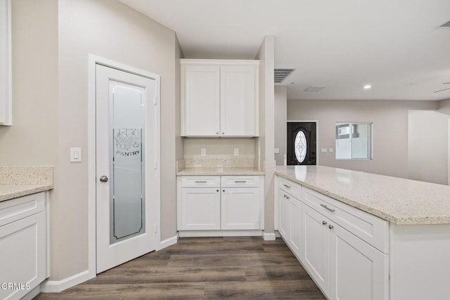 40719 E 171st St E, Lake Los Angeles, CA 93535 - kitchen with a peninsula, white cabinetry, dark wood finished floors, light stone countertops, and baseboards