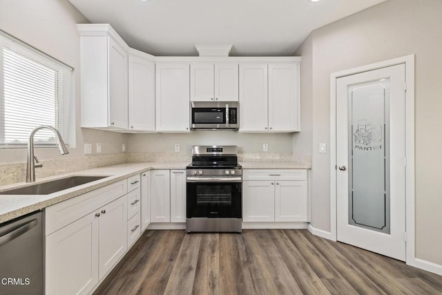 40719 E 171st St E, Lake Los Angeles, CA 93535 - kitchen with stainless steel appliances, a sink, white cabinetry, and dark wood-style floors