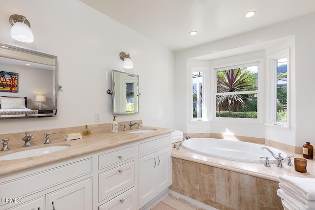 bathroom featuring a garden tub, double vanity, and recessed lighting