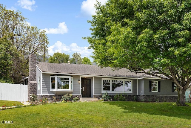 ranch-style home featuring stone siding and a chimney
