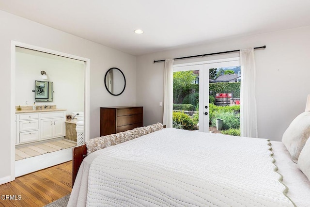 bedroom featuring access to exterior, light wood-style flooring, connected bathroom, recessed lighting, and a sink