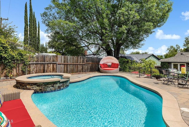 view of pool featuring a patio area, a fenced backyard, and a pool with connected hot tub