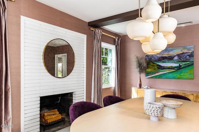 dining room featuring a fireplace and beam ceiling