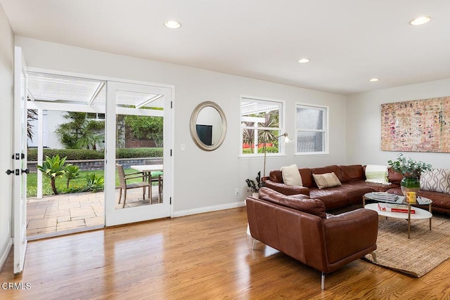 living room featuring plenty of natural light, wood finished floors, recessed lighting, and baseboards