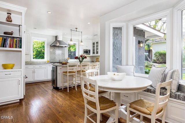 dining room with dark wood-style flooring, beverage cooler, and recessed lighting