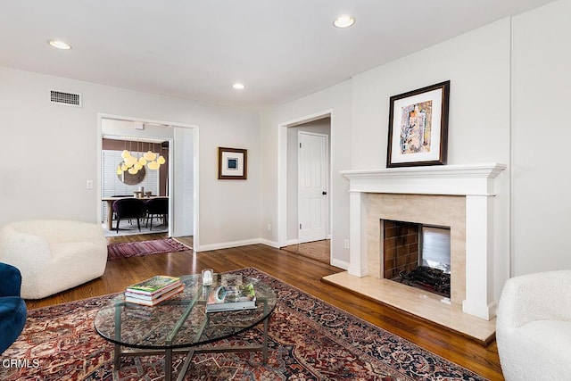 living room featuring wood finished floors, a fireplace, recessed lighting, and baseboards