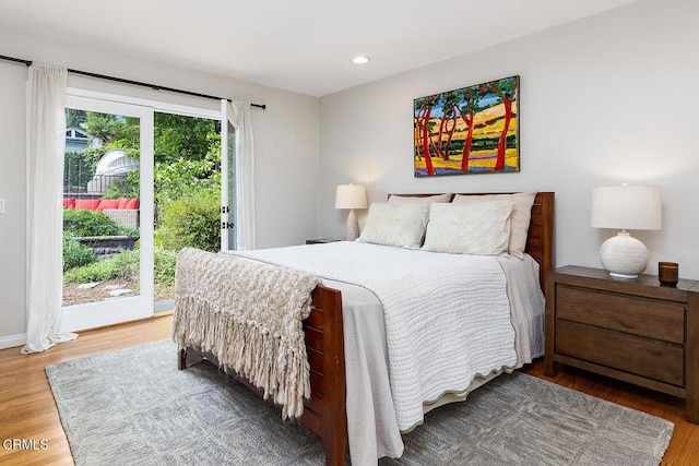 bedroom with access to exterior, wood finished floors, and recessed lighting