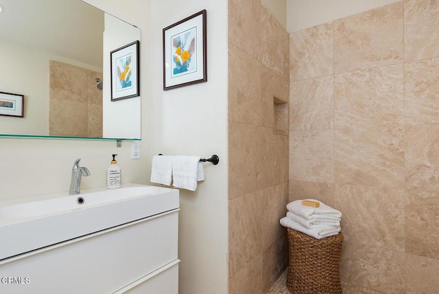 full bath featuring vanity and a tile shower