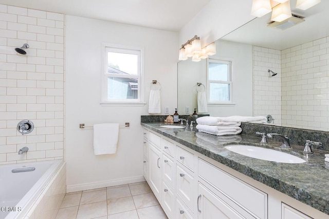 bathroom with tile patterned floors, plenty of natural light, double vanity, and tiled shower / bath