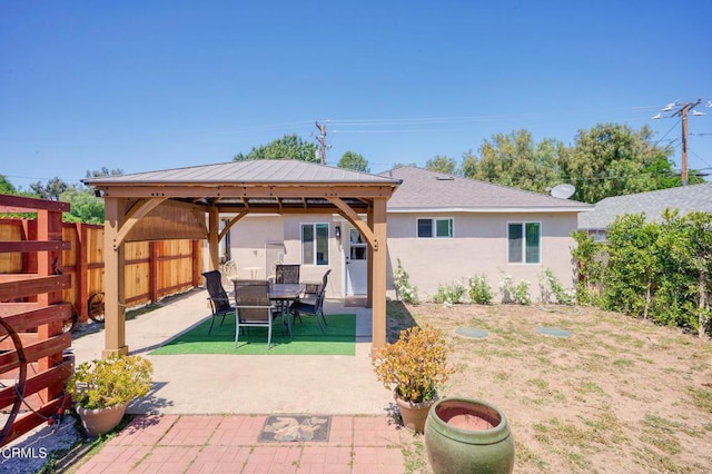 fenced backyard with a gazebo and a patio