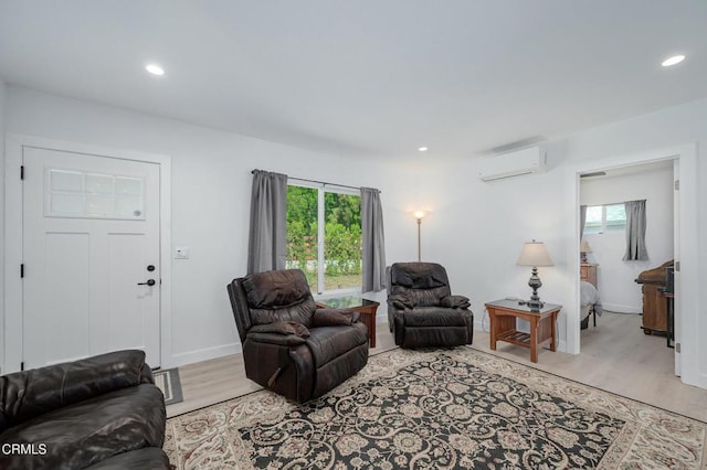 living room featuring an AC wall unit, light wood-type flooring, recessed lighting, and baseboards