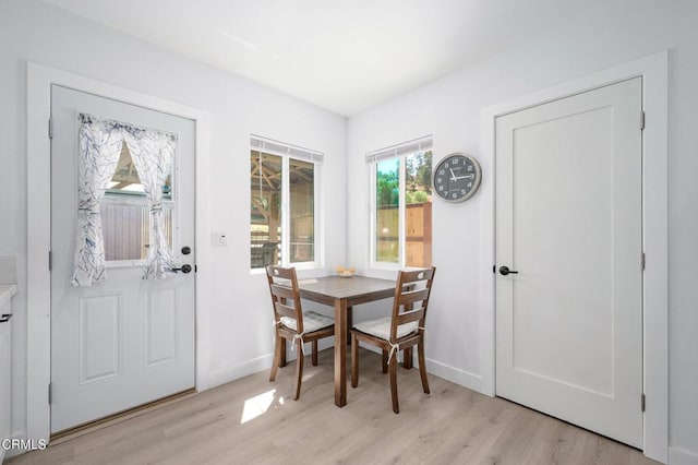 dining area with light wood finished floors and baseboards