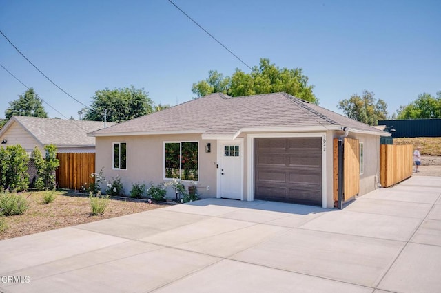 ranch-style home featuring a garage, driveway, and a shingled roof