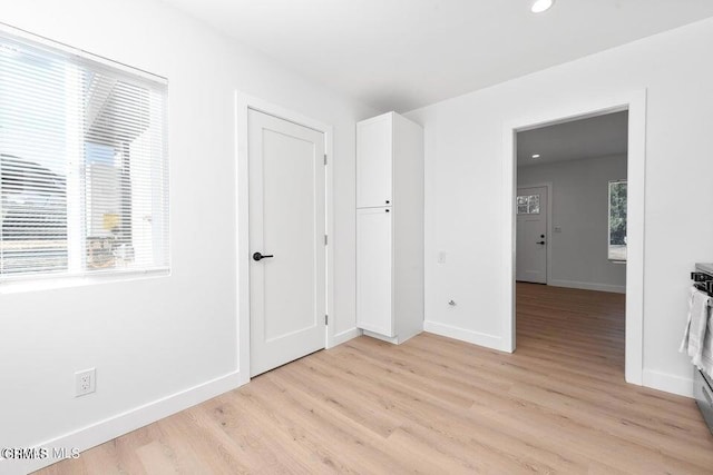unfurnished bedroom featuring light wood-style flooring, baseboards, and recessed lighting