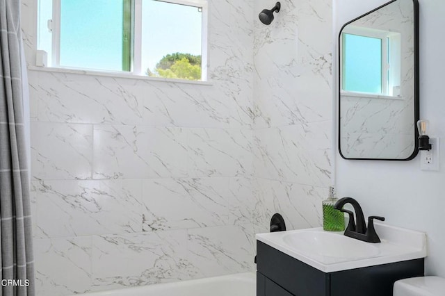 full bath with shower / tub combination, vanity, healthy amount of natural light, and toilet