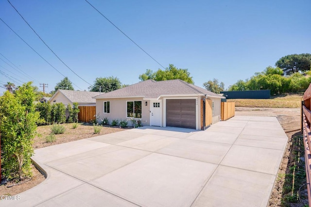 ranch-style house with driveway, a garage, and stucco siding