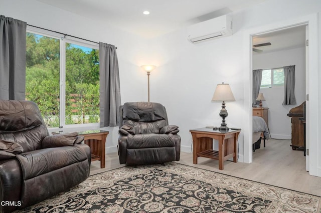 living area featuring a wall mounted AC, wood finished floors, recessed lighting, and baseboards