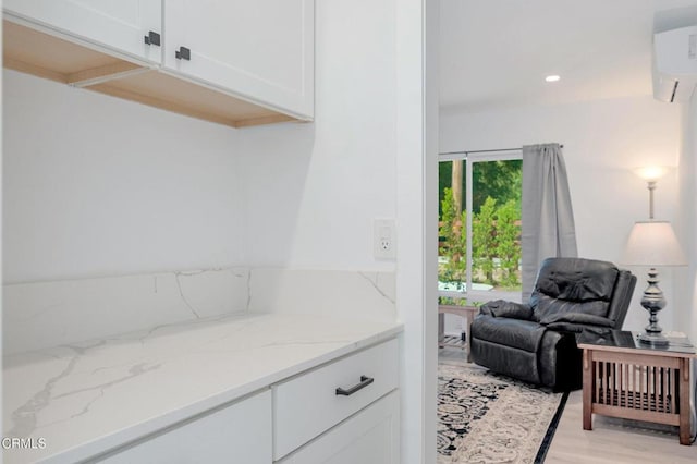 interior space with a wall mounted AC, light wood-style floors, and recessed lighting