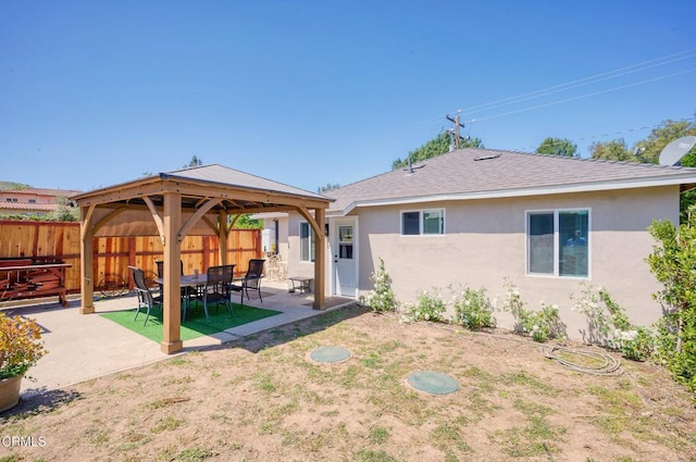 back of house featuring a gazebo, stucco siding, a patio area, and a shingled roof