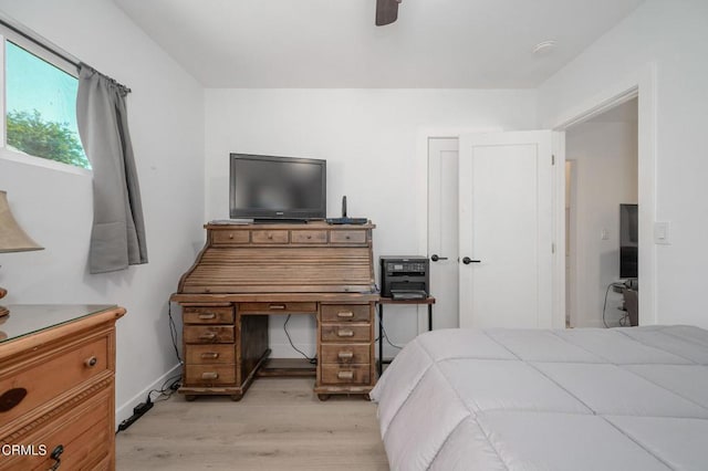 bedroom with light wood finished floors, ceiling fan, and baseboards