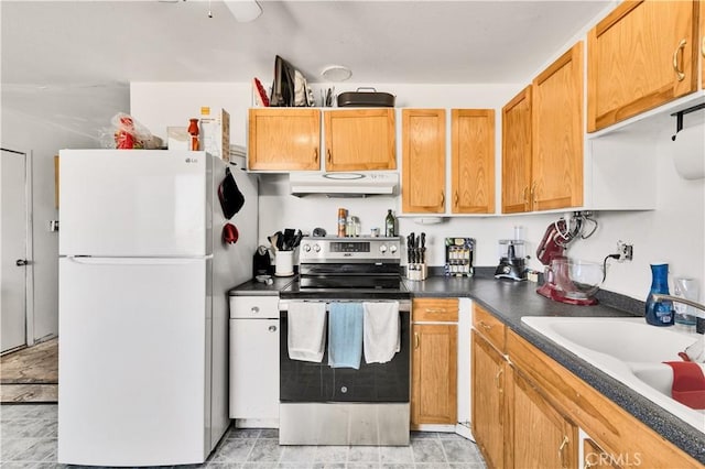 kitchen featuring stainless steel range with electric stovetop, freestanding refrigerator, under cabinet range hood, dark countertops, and a sink
