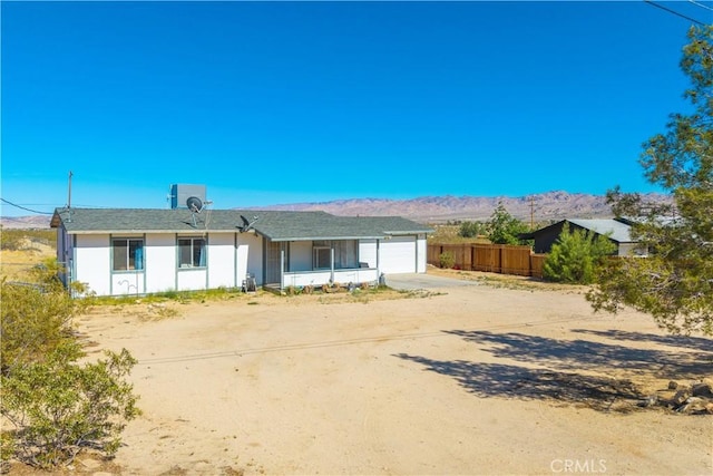 single story home featuring driveway, an attached garage, and a mountain view