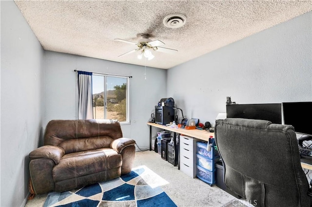 office area featuring a ceiling fan, light colored carpet, and a textured ceiling