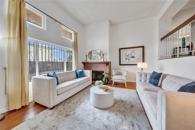 109 N Nicholson Ave Unit A, Monterey Park, CA 91755 - living room with wood finished floors, a brick fireplace, baseboards, and a textured ceiling