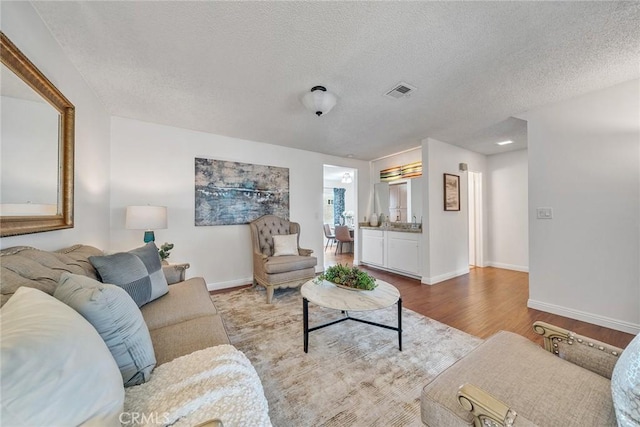 109 N Nicholson Ave Unit A, Monterey Park, CA 91755 - living area featuring a textured ceiling, light wood-type flooring, and baseboards