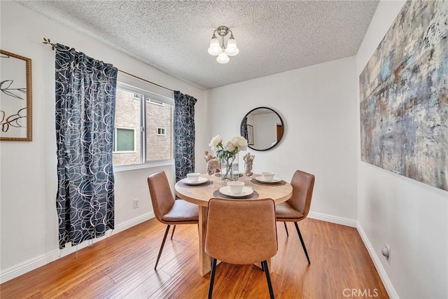 109 N Nicholson Ave Unit A, Monterey Park, CA 91755 - dining space featuring wood finished floors, a textured ceiling, baseboards, and a chandelier