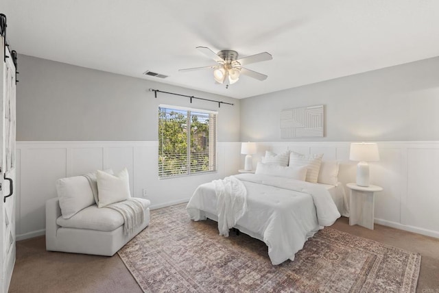 1109 Chimney Flats Ln, Chula Vista, CA 91915 - bedroom featuring a barn door, a wainscoted wall, carpet flooring, a decorative wall, and ceiling fan