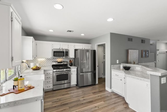 1109 Chimney Flats Ln, Chula Vista, CA 91915 - kitchen with stainless steel appliances, tasteful backsplash, white cabinets, and recessed lighting