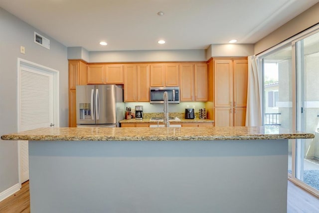178 Via Montisi, Santee, CA 92071 - kitchen with appliances with stainless steel finishes, light wood finished floors, a kitchen island with sink, light brown cabinetry, and light stone countertops