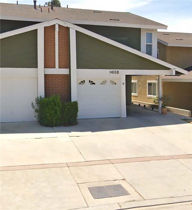 14158 Paddock St, Sylmar, CA 91342 - view of side of home with brick siding, a garage, driveway, and stucco siding