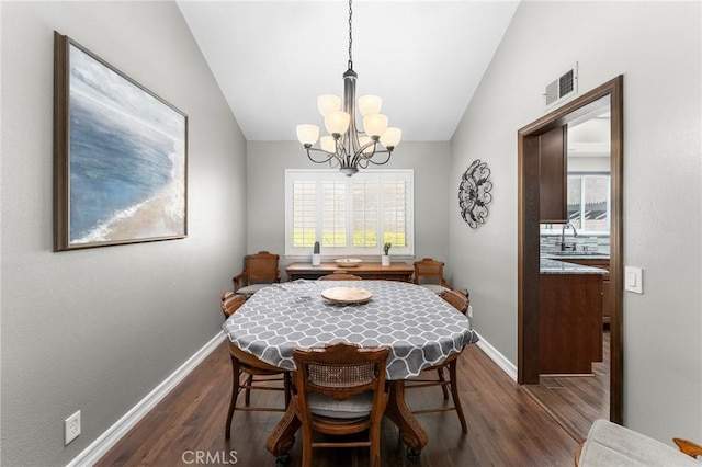 dining area with lofted ceiling, a chandelier, dark wood-style flooring, and baseboards
