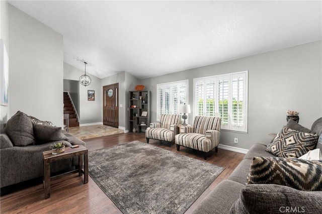 living area with baseboards, stairway, lofted ceiling, and wood finished floors