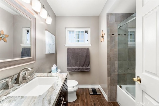 full bath with baseboards, toilet, wood finished floors, and vanity