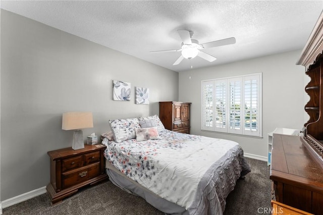bedroom featuring dark carpet, baseboards, a textured ceiling, and ceiling fan