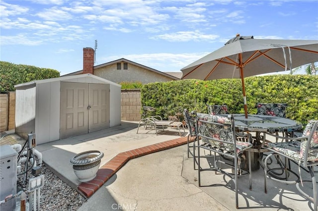 view of patio / terrace with a shed, outdoor dining space, and an outdoor structure