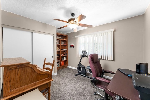 carpeted office featuring ceiling fan, baseboards, and a textured ceiling