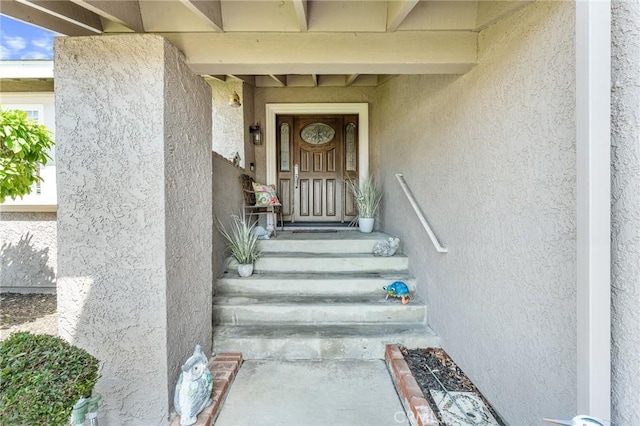 view of exterior entry featuring stucco siding