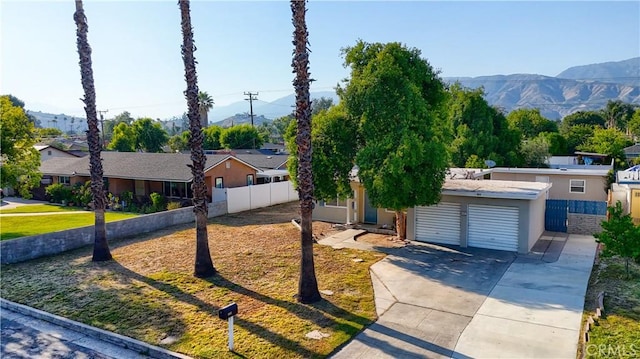 214 E Marshall Blvd, San Bernardino, CA 92404 - ranch-style house featuring concrete driveway, a mountain view, an attached garage, and stucco siding