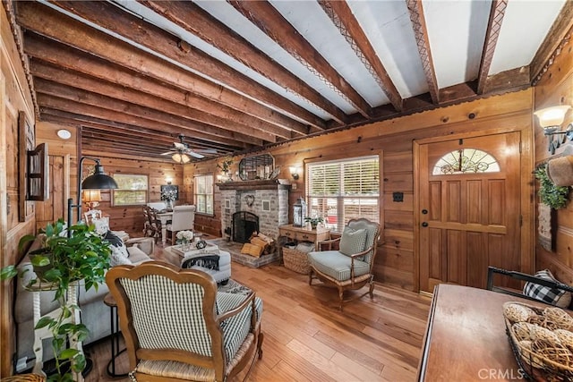 795 Glen View Ln, Twin Peaks, CA 92391 - living room with wooden walls, beamed ceiling, hardwood / wood-style floors, a ceiling fan, and a large fireplace